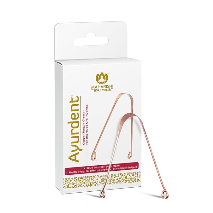Ayurdent product packaging with rose gold metal tool on a white background