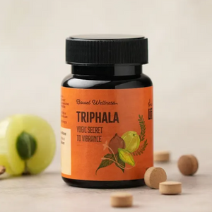 Triphala supplement bottle with orange label on a light background