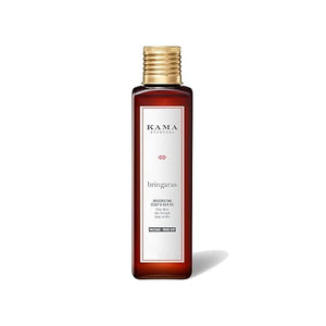 A bottle of Kama Ayurveda Bringaras Resurfacing Hair & Hair Oil in a dark amber glass bottle with a gold cap and a white label, shown on a white background with a soft shadow.