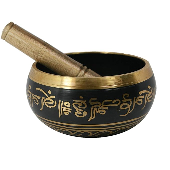 Black singing bowl with gold accents and wooden handle on a white background